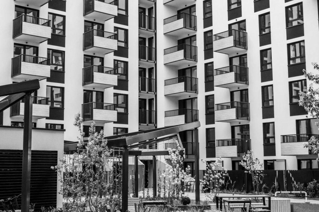 Contemporary urban apartment building with balconies and courtyard, black and white.